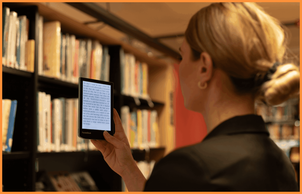Kobieta trzymająca czytnik e-book w ręku w bibliotece